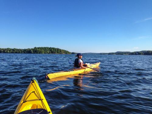 a person sitting on a kayak in the water at Liljeholmen Herrgård Hostel in Rimforsa