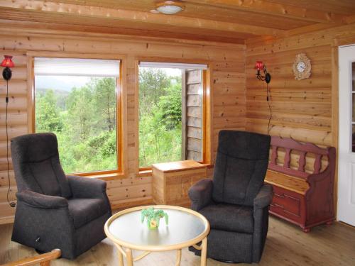 a living room with two chairs and a table at Chalet Julie by Interhome in Eikelandsosen