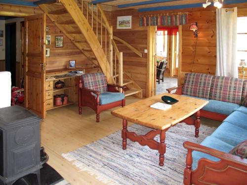 a living room with a table and a stove at Chalet Elisabeth by Interhome in Eikelandsosen