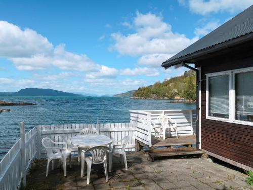 a house with chairs and a table on a deck at Holiday Home Jokobu - FJH087 by Interhome in Skånevik