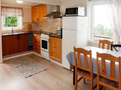 SørbøにあるHoliday Home Solbris by Interhomeの白い冷蔵庫とテーブルのあるキッチン