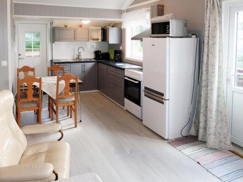 a kitchen with a white refrigerator and a table at Holiday Home Fjordperlen by Interhome in Sørbø