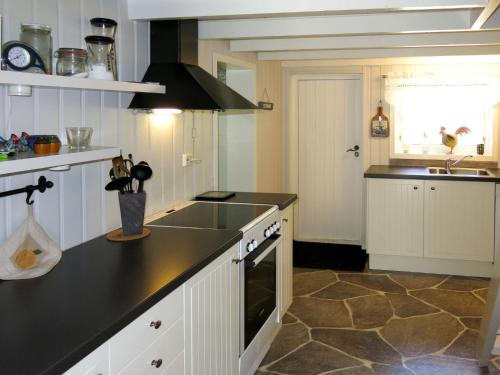 una cocina con encimera negra y fregadero en Chalet Nedregård - SOW002 by Interhome, en Farsund