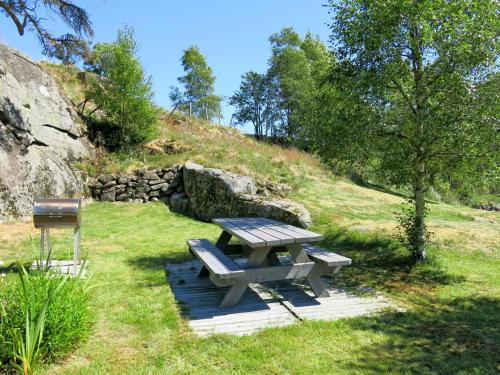 a picnic table in the grass in a field at Chalet Nedregård by Interhome in Farsund