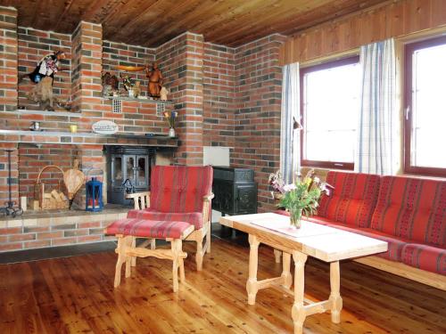 sala de estar con sillas rojas y pared de ladrillo en Chalet Moebu - SOO040 by Interhome, en Mjåvatn