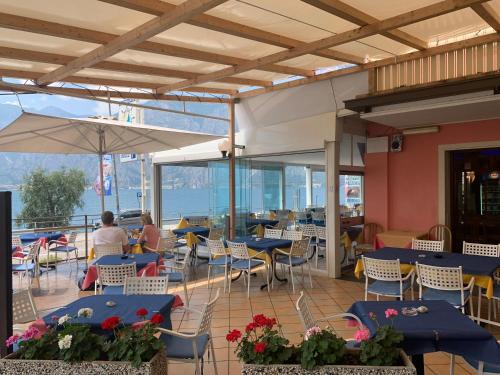 a patio area with tables, chairs and umbrellas at Hotel Vela Azzurra in Malcesine