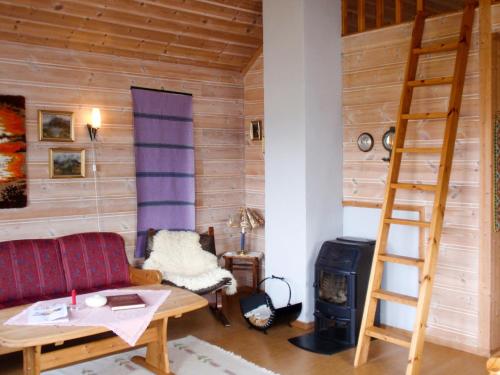 uma sala de estar com um sofá e um fogão a lenha em Chalet Slåttenes - FJH415 by Interhome em Naustflot