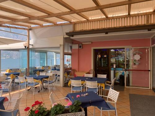 a restaurant with blue tables and chairs and the ocean at Hotel Vela Azzurra in Malcesine