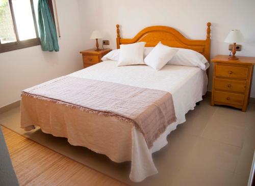 a bedroom with a large bed and two night stands at Mediterranea in La Pineda