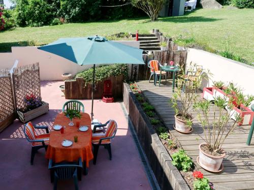 une table et des chaises avec un parasol sur une terrasse dans l'établissement Apartment Le Clos du Port 2 by Interhome, à Saint-Cast-le-Guildo