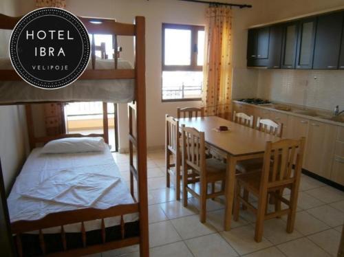 Habitación con cama, mesa y sillas. en Hotel Ibra en Velipojë