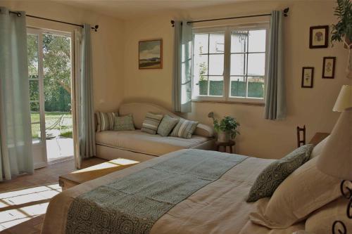 1 dormitorio con cama, sofá y ventanas en La Vieille Ferme de Grasse, en Grasse