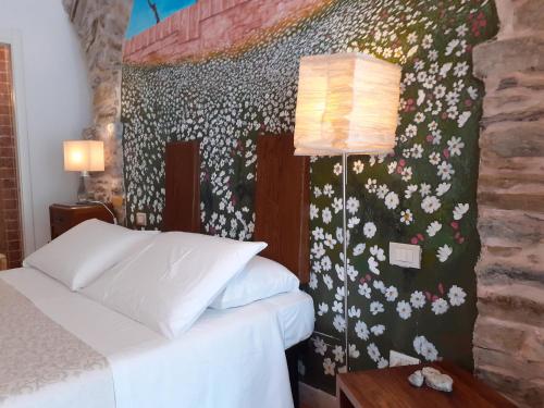 a bedroom with a bed and a wall with flowers at Scaglie di Mare in Manarola