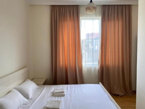 um quarto com uma cama branca e uma janela em West House em Kobuleti