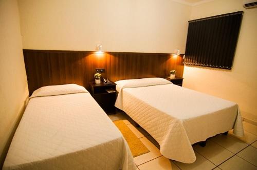 a hotel room with two beds in a room at Mediterrâneo Park Hotel in Três Lagoas