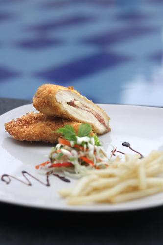 a white plate with a piece of food and pasta at Vrata Hotel Yogyakarta in Kalasan