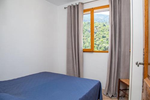 SerrieraにあるAppartements A Merendellaのベッドルーム(青いベッド1台、窓付)