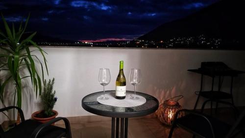 a table with two glasses and a bottle of wine at Apartman Sunset Trebinje in Trebinje
