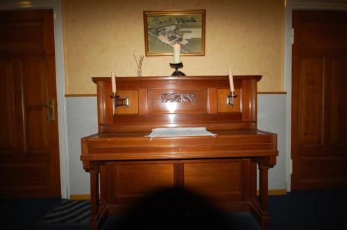 un pianoforte di legno con una candela sopra di Pension Pohnsdorfer Mühle a Sierksdorf