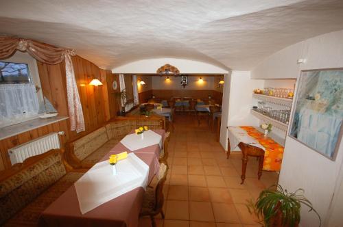ein Restaurant mit Tischen und Stühlen in einem Zimmer in der Unterkunft Pension Pohnsdorfer Mühle in Sierksdorf