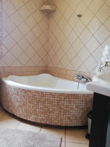 a bath tub in a bathroom with a sink at Willa IDYLLA in Kołobrzeg