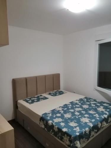 a bedroom with a bed with a blue blanket on it at Vila Ena in Stanišiči
