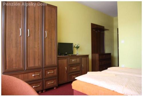 1 dormitorio con 1 cama, vestidor y TV en Alpský dom Vitanová en Vitanová