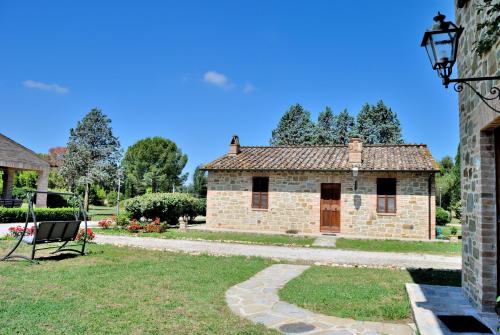 a brick building with a bench in a yard at I Casali Della Ghisleria in Ospedalicchio