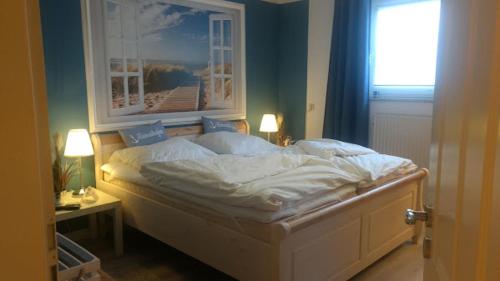 a bedroom with a bed with a picture on the wall at DerOstseegast in Heiligenhafen