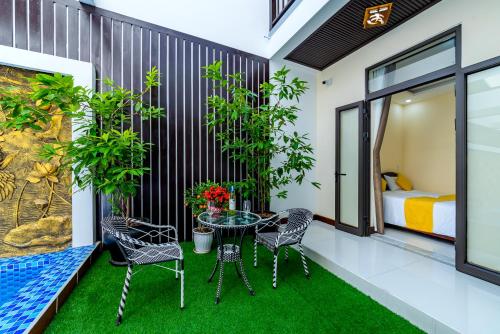 a balcony with a table and chairs and a bed at Green Hill Hotel in Hoi An
