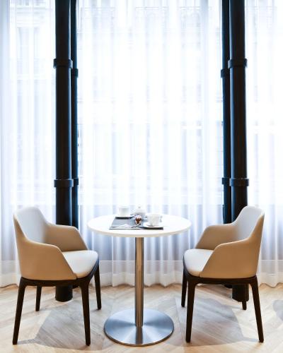 two chairs and a table and a table and chairs at Hôtel R de Paris - Boutique Hotel in Paris