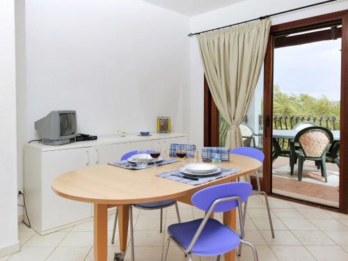 kuchnia i jadalnia ze stołem i krzesłami w obiekcie Apartment L'Uddastru trilo by Interhome w mieście San Teodoro