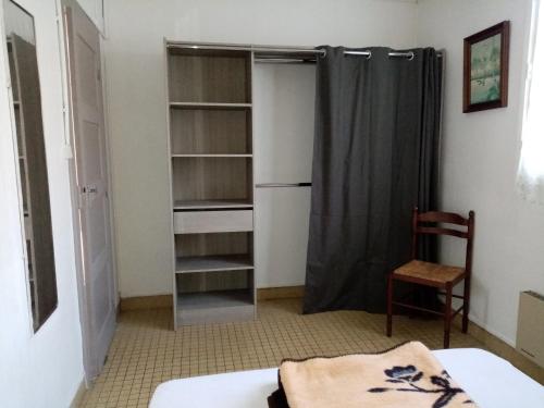 - une chambre avec un placard, un lit et une chaise dans l'établissement le Moustic, à Léon