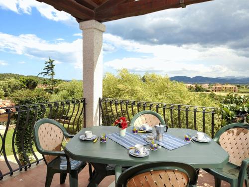 a green table with chairs on a balcony at Apartment Lu Fraili - TEO220 by Interhome in San Teodoro