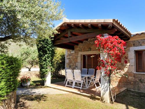 a patio with two chairs under a wooden pergola at Apartment Lu Fraili - TEO220 by Interhome in San Teodoro