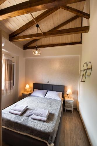 a bedroom with a bed with two towels on it at Stone Villa Hermione in Kariá