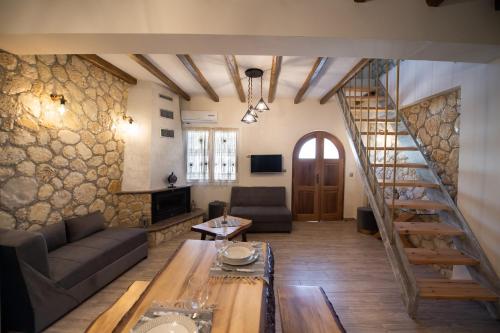 - un salon avec un escalier en colimaçon dans un bâtiment dans l'établissement Stone Villa Hermione, à Kariá