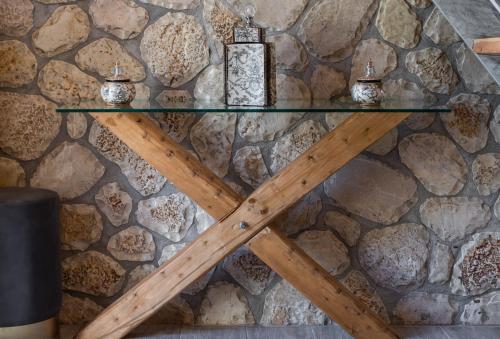 une table en verre avec une étoile en bois sur un mur en pierre dans l'établissement Stone Villa Hermione, à Kariá