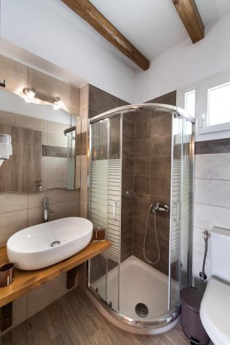 a bathroom with a shower and a sink and a tub at Stone Villa Hermione in Kariá