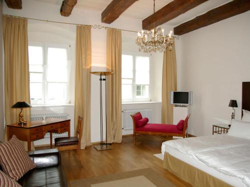 Schlafzimmer mit einem Bett, einem Schreibtisch und einem Stuhl in der Unterkunft Hotel Goldenes Kreuz in Regensburg