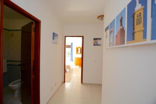 a bathroom with a toilet and a hallway at Casa Fragata B in Armação de Pêra