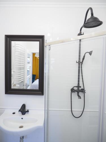 a bathroom with a shower and a sink and a mirror at Apartamenty Stary Browar Oleśnica in Oleśnica