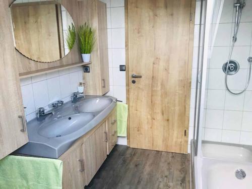 uma casa de banho com um lavatório, um espelho e uma banheira em Ferienwohnung Anna mit Blick ins Grüne em Moosbach