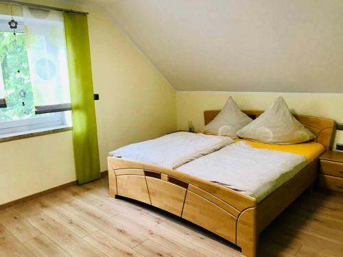 um quarto com uma cama num quarto com uma janela em Ferienwohnung Anna mit Blick ins Grüne em Moosbach