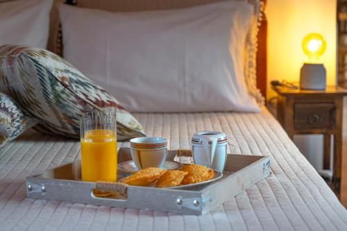 a tray with food and drinks on a bed at Madalena's Summer House in Adamantas