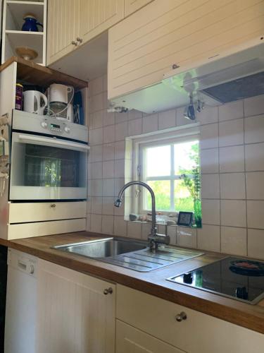 a kitchen with a sink and a microwave at Paradiset Östra Öland in Nedra Sandby