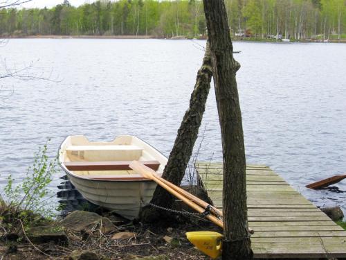 un barco amarrado a un muelle en un lago en Holiday Home Åkekvarn Snärjet by Interhome, en Olofström