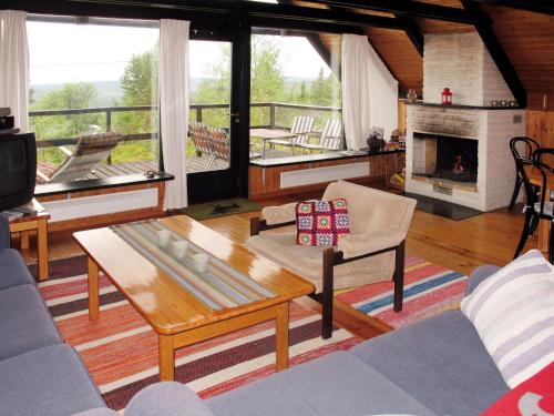 een woonkamer met een salontafel en een open haard bij Chalet Lofsdalen Fjällbjörken - HJD054 by Interhome in Lofsdalen