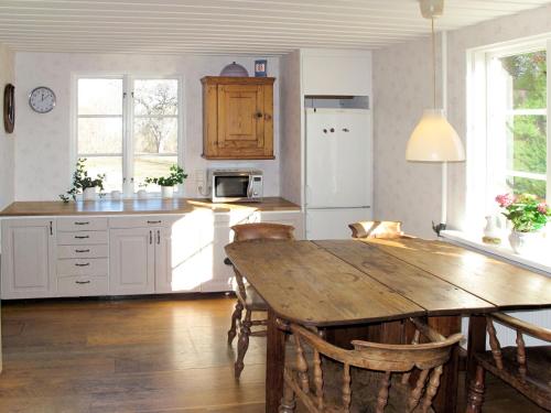 a kitchen with a wooden table and a dining room at Chalet Ilandet by Interhome in Gnesta