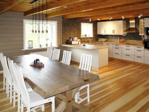 a kitchen with a wooden table and white chairs at Chalet Kvisthån Idegranen - HJD059 by Interhome in Vemhån